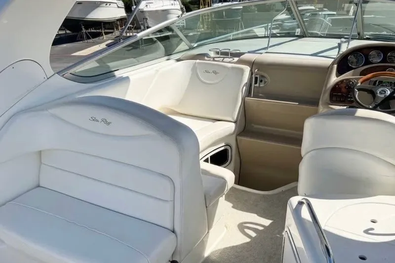 Slide: The Image of 2005 Sea Ray Sundancer 280 boat interior with white seating and control panel. - 2