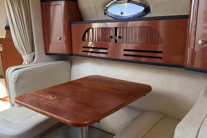 Slide: The Image of Interior of 2005 Sea Ray Sundancer 280 with wooden table and cabinetry. - 8