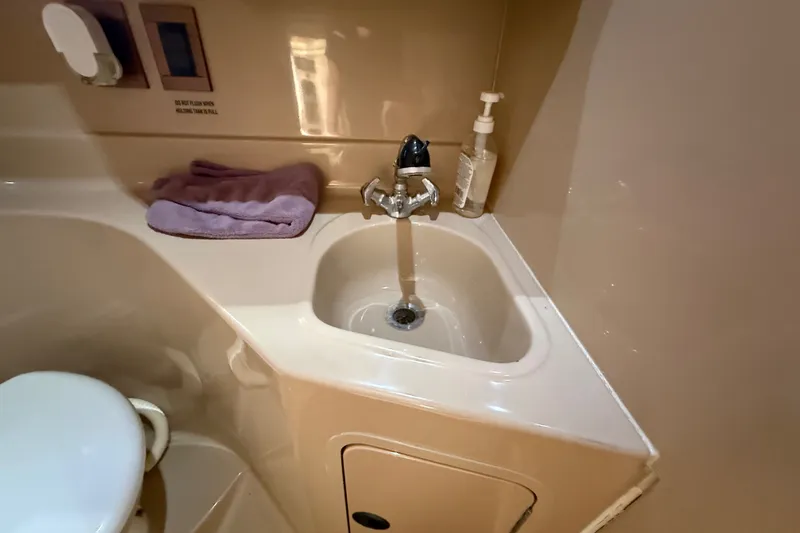 Slide: The Image of Bathroom sink area in 1999 Cruisers Yachts 3075 Rogue with faucet and toiletries. - 49