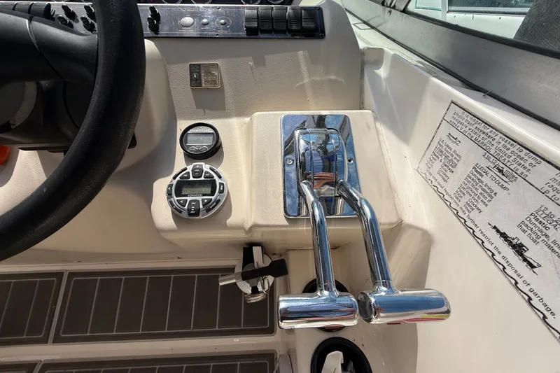 Slide: The Image of 1999 Cruisers Yachts 3075 Rogue helm controls with steering wheel and throttle levers. - 26