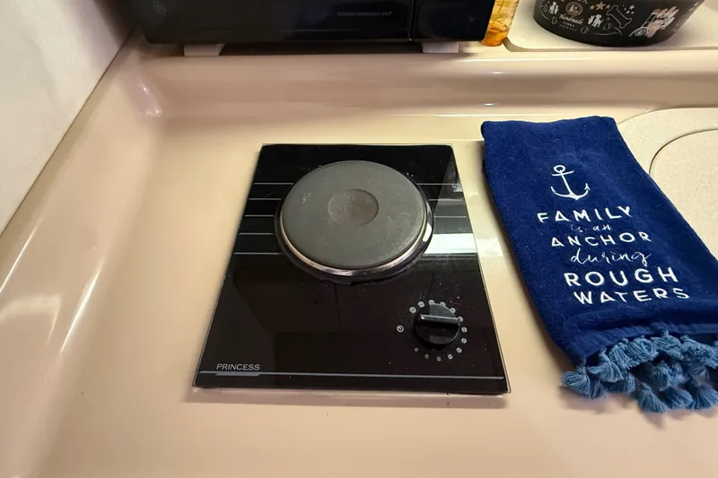 Slide: The Image of Stovetop on 1999 Cruisers Yachts 3075 Rogue with nautical-themed towel. - 38