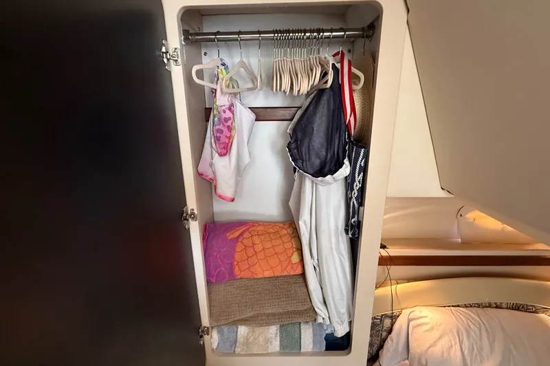 Slide: The Image of Closet inside 1999 Cruisers Yachts 3075 Rogue with clothes and towels neatly arranged. - 46