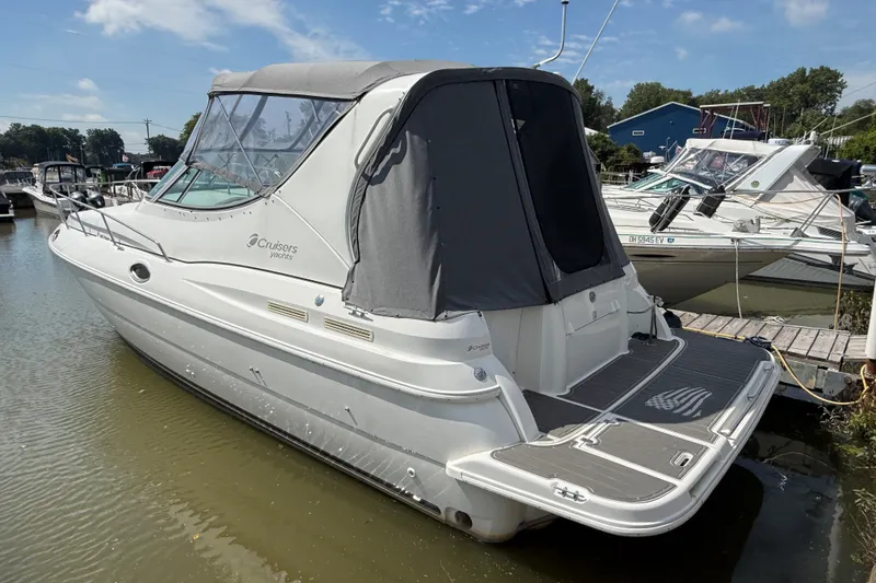 The Image of 1999 Cruisers Yachts 3075 Rogue docked, featuring sleek design and covered cockpit. - 0
