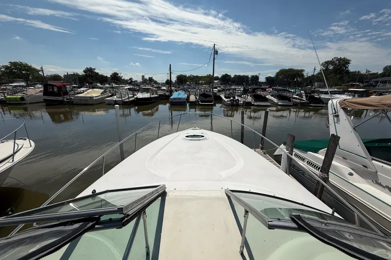 Slide: The Image of 1999 Cruisers Yachts 3075 Rogue docked at a marina under a clear blue sky. - 18