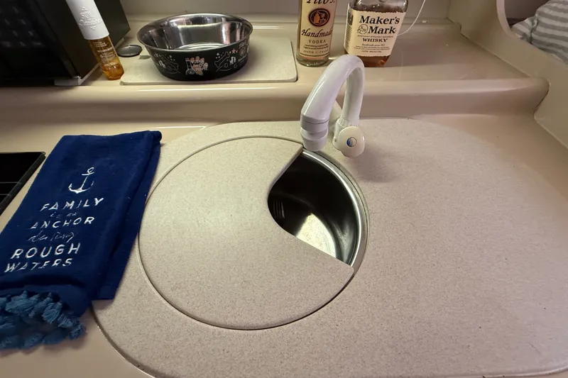 Slide: The Image of 1999 Cruisers Yachts 3075 Rogue sink area with faucet, towel, and bottles. - 37