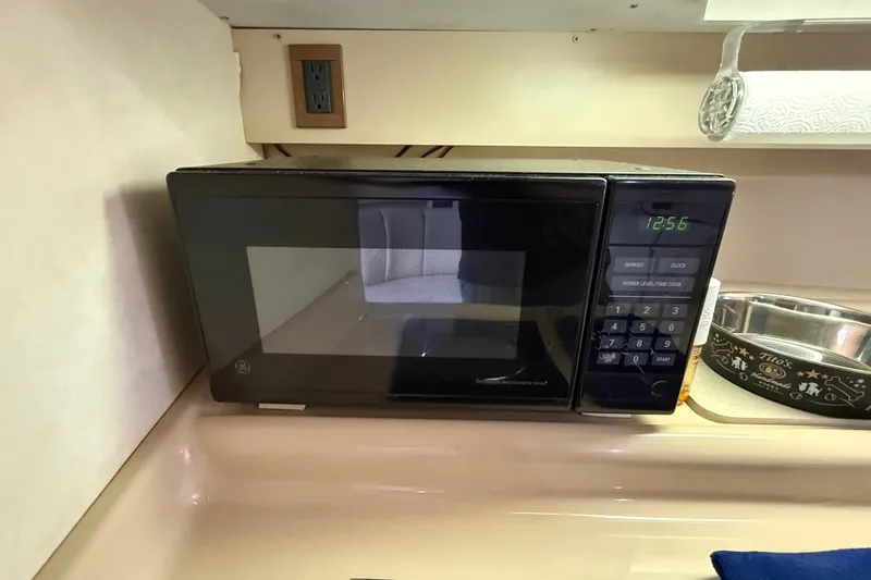 Slide: The Image of Microwave in 1999 Cruisers Yachts 3075 Rogue kitchen area, with digital clock display. - 39