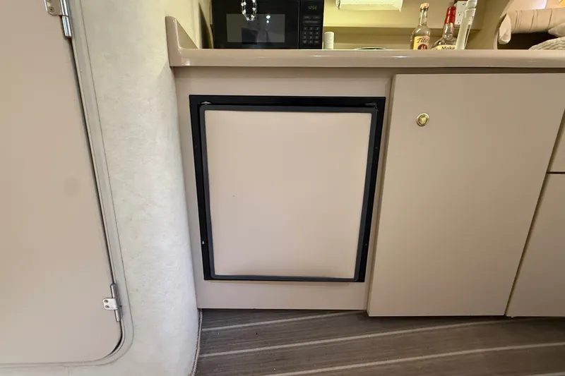 Slide: The Image of 1999 Cruisers Yachts 3075 Rogue interior kitchenette with fridge and cabinets. - 40