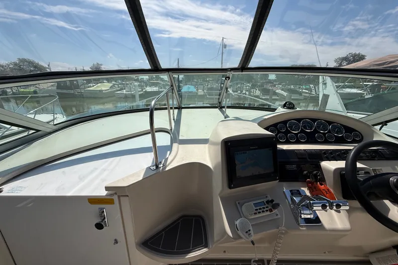Slide: The Image of 1999 Cruisers Yachts 3075 Rogue helm with navigation equipment and marina view. - 17