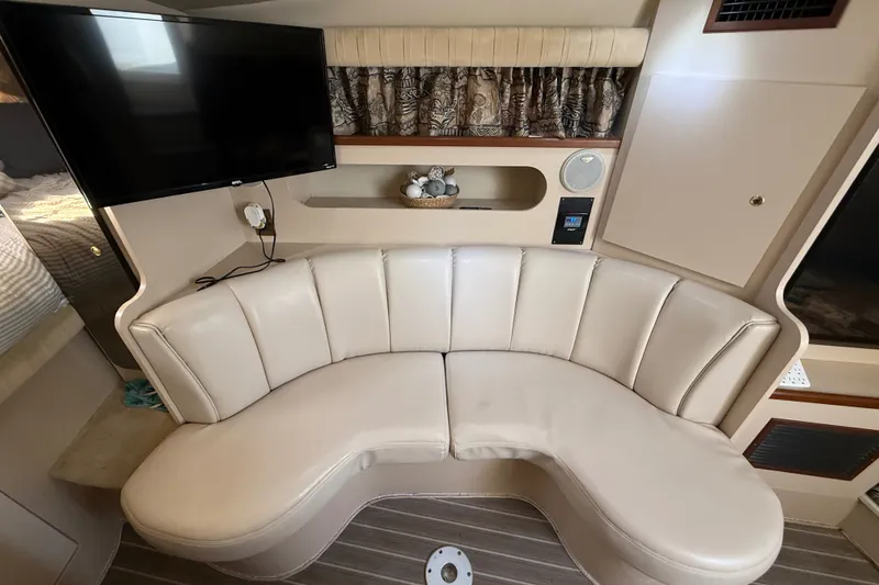 Slide: The Image of 1999 Cruisers Yachts 3075 Rogue interior with curved leather seating and mounted TV. - 31