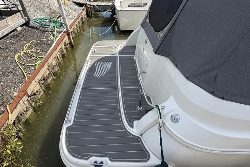 Slide: The Image of 1999 Cruisers Yachts 3075 Rogue docked, featuring a sleek gray deck design. - 6