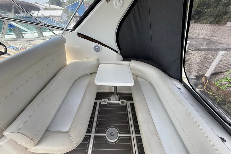 Slide: The Image of 1999 Cruisers Yachts 3075 Rogue interior with white seating and small table. - 9