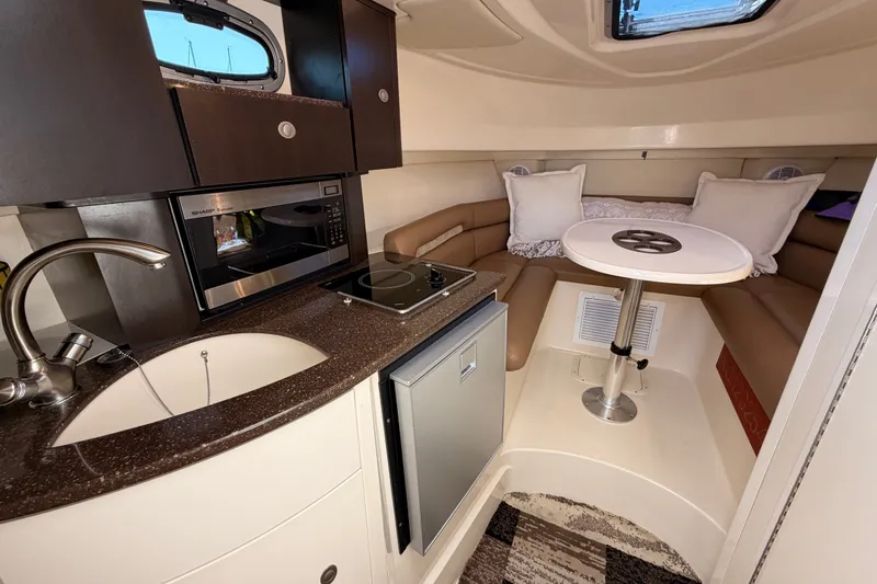 Slide: The Image of 2007 Boston Whaler 285 Conquest cabin with kitchenette, seating, and table. - 33