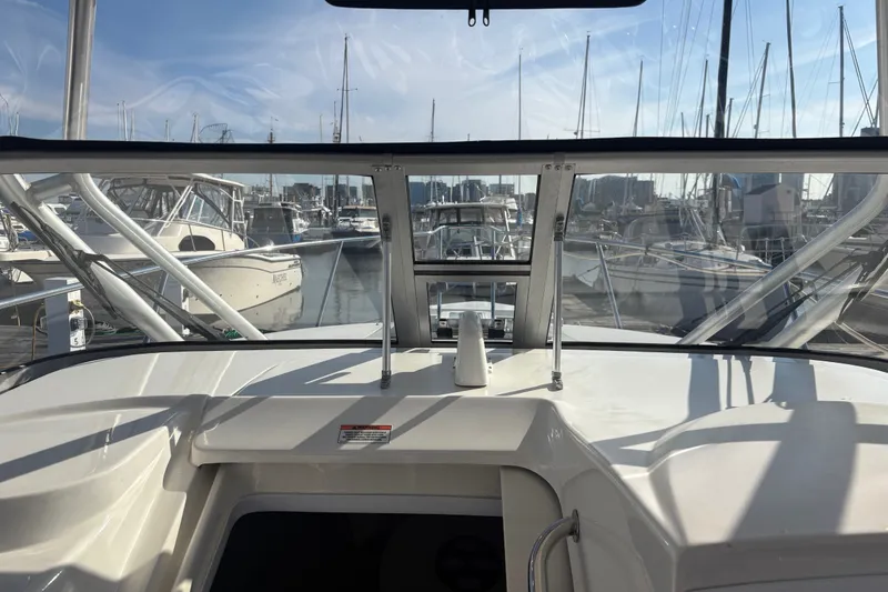 Slide: The Image of 2007 Boston Whaler 285 Conquest boat docked at a marina, surrounded by other vessels. - 32