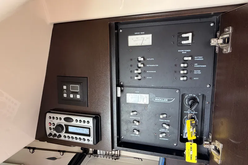Slide: The Image of Control panel of a 2007 Boston Whaler 285 Conquest boat, featuring various switches and gauges. - 44