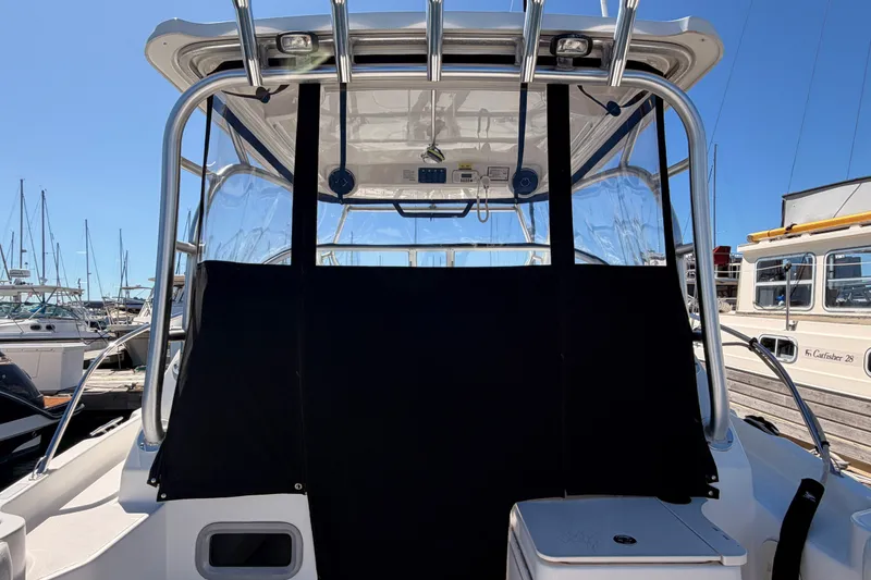 Slide: The Image of 2007 Boston Whaler 285 Conquest boat with covered cockpit, docked at marina. - 14
