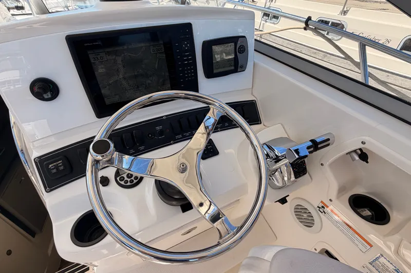 Slide: The Image of Helm of 2007 Boston Whaler 285 Conquest with navigation controls and steering wheel. - 24