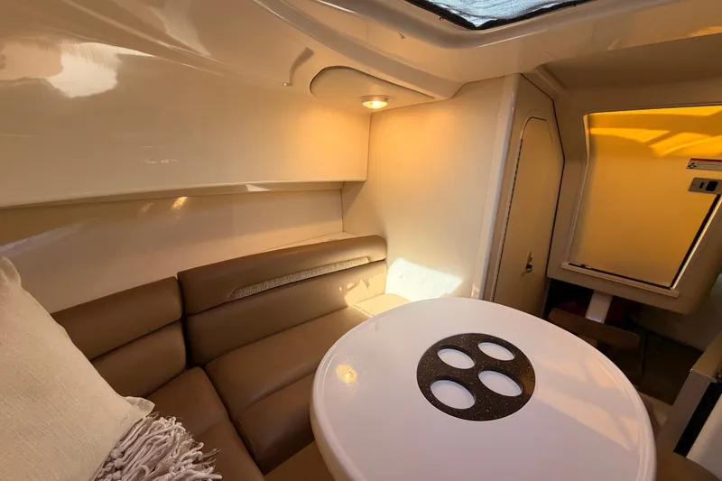 Slide: The Image of Interior of 2007 Boston Whaler 285 Conquest, featuring cozy seating and a round table. - 38