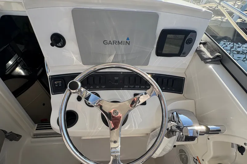 Slide: The Image of 2007 Boston Whaler 285 Conquest helm with Garmin navigation system and steering wheel. - 25