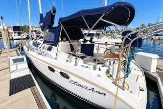 Slide: The Image of Hunter 376 sailboat, 1996 model, docked at marina with blue canopy and clear skies. - 1