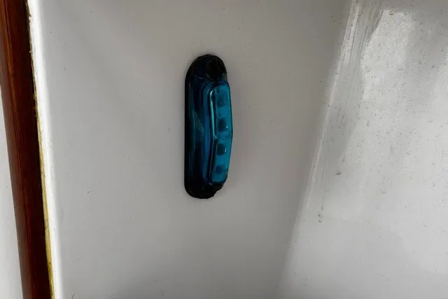 Slide: The Image of Blue light fixture on a 1973 C&C 48 boat's white surface. - 30