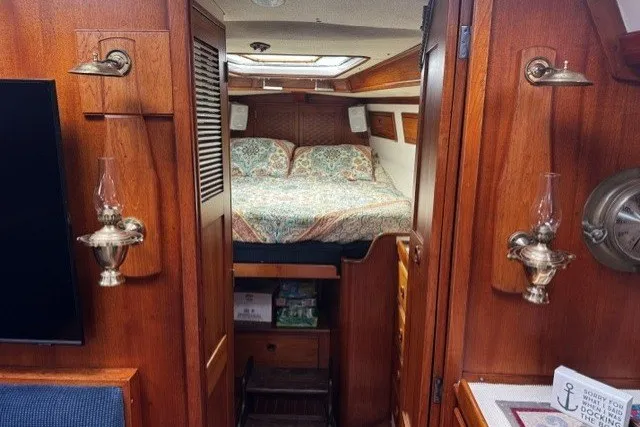 Slide: The Image of Cozy cabin interior of a 1973 C&C 48 sailboat with wood paneling and a double bed. - 25