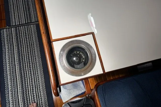 Slide: The Image of Compass embedded in a 1973 C&C 48 yacht's wooden interior table. - 13