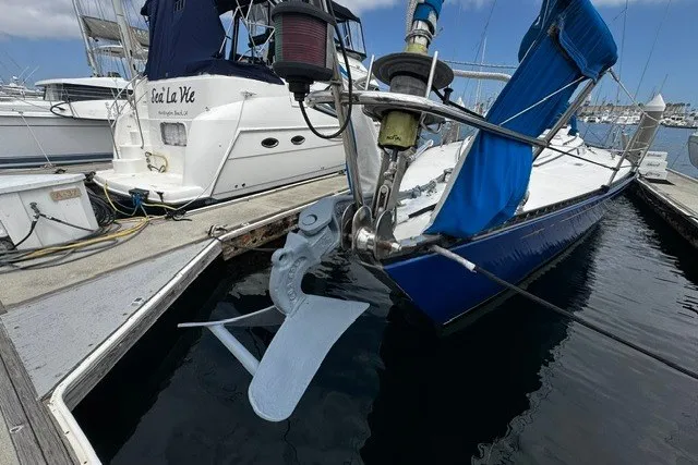 Slide: The Image of Sailboat docked at marina, featuring a 1973 C&C 48 model with blue hull and anchor. - 45