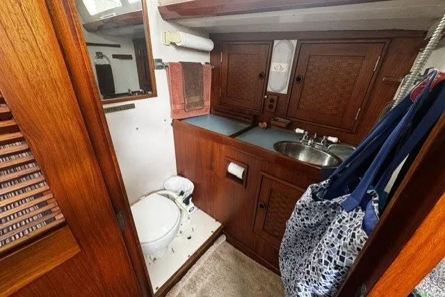 Slide: The Image of 1973 C&C 48 yacht bathroom with wooden cabinetry, sink, and toilet. - 24