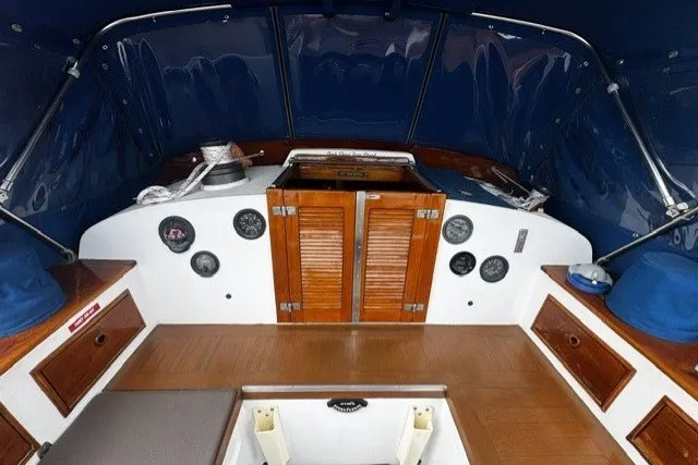 Slide: The Image of Interior of a 1973 C&C 48 sailboat with wooden cabinetry and blue accents. - 26