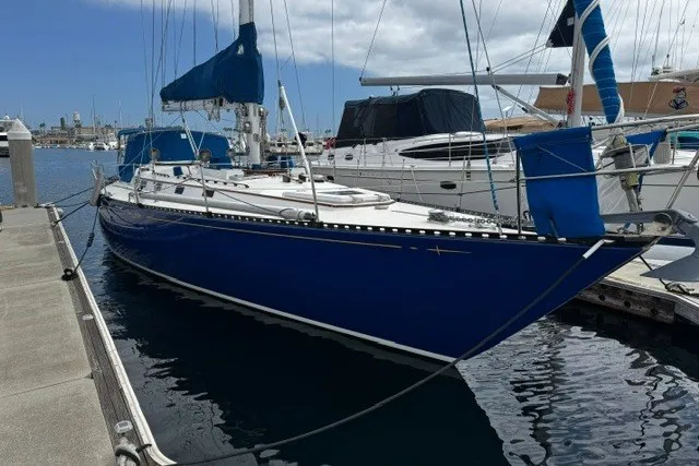 Slide: The Image of 1973 C&C 48 sailboat docked in marina, featuring sleek blue hull and white deck. - 50