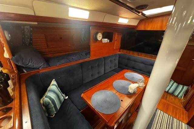 Slide: The Image of Cozy interior of a 1973 C&C 48 sailboat with blue seating and wooden accents. - 15