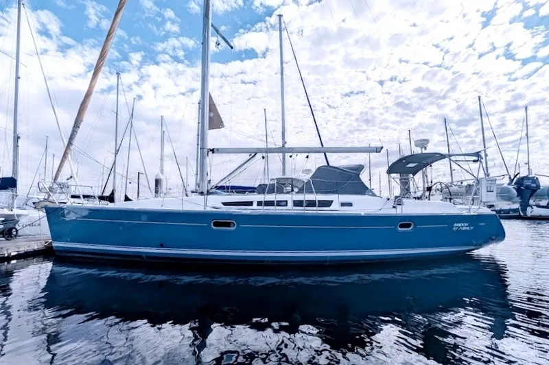 Slide: The Image of 2006 Jeanneau Sun Odyssey 45 sailboat docked in a marina under a cloudy sky. - 1