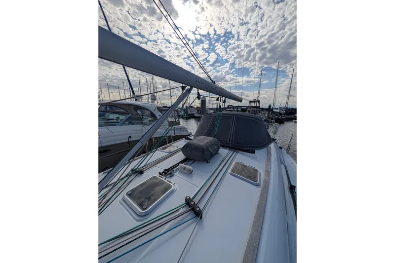 Slide: The Image of 2006 Jeanneau Sun Odyssey 45 sailboat docked under a cloudy sky. - 13