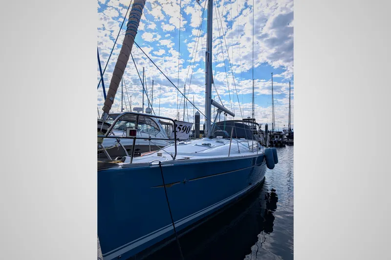 Slide: The Image of 2006 Jeanneau Sun Odyssey 45 sailboat docked under a partly cloudy sky. - 2
