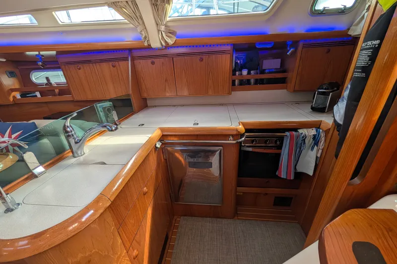 Slide: The Image of Interior of 2006 Jeanneau Sun Odyssey 45 yacht kitchen with wood cabinetry and modern appliances. - 29