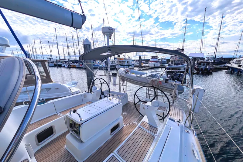 Slide: The Image of 2006 Jeanneau Sun Odyssey 45 sailboat docked in a marina, featuring dual steering wheels. - 5