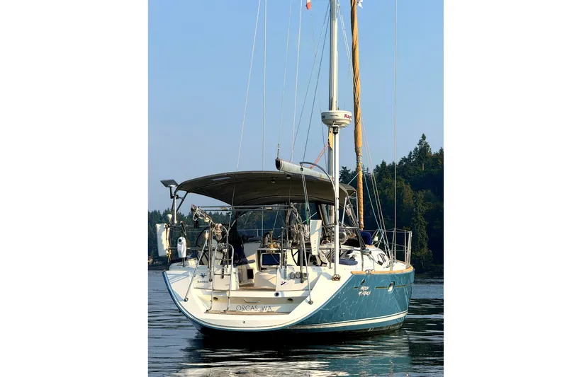 Slide: The Image of 2006 Jeanneau Sun Odyssey 45 sailboat anchored on calm water, surrounded by trees. - 3
