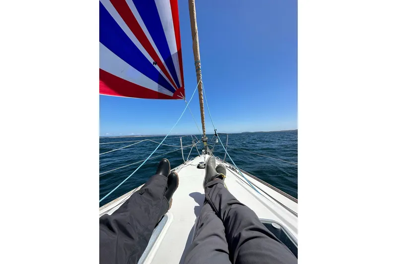Slide: The Image of Two people relaxing on a 2006 Jeanneau Sun Odyssey 45 sailboat at sea. - 51