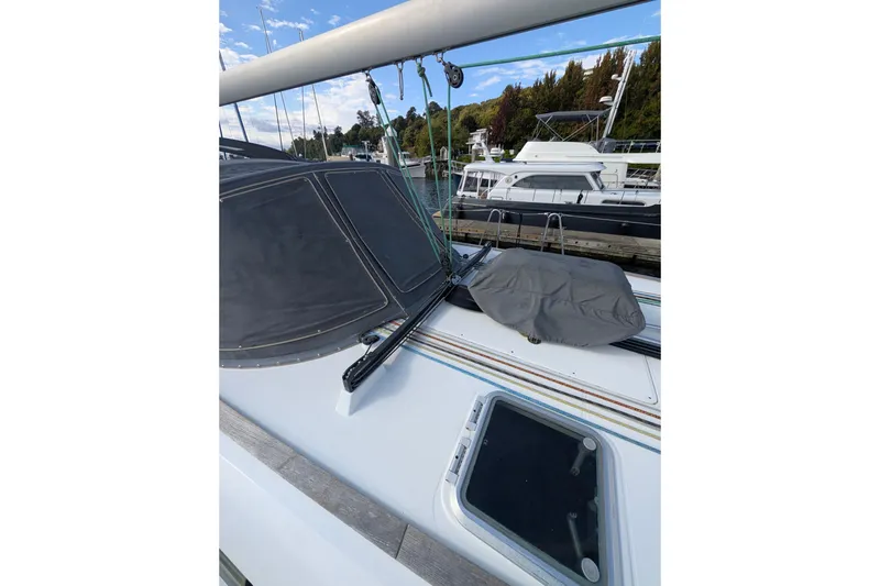 Slide: The Image of 2006 Jeanneau Sun Odyssey 45 sailboat deck with covered equipment and marina view. - 12