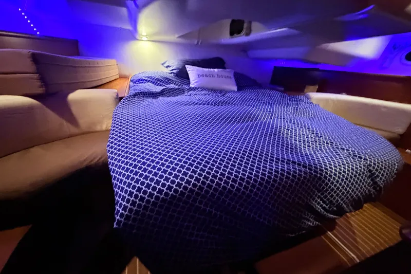 Slide: The Image of Cozy cabin interior of 2006 Jeanneau Sun Odyssey 45 with blue bedding and ambient lighting. - 37
