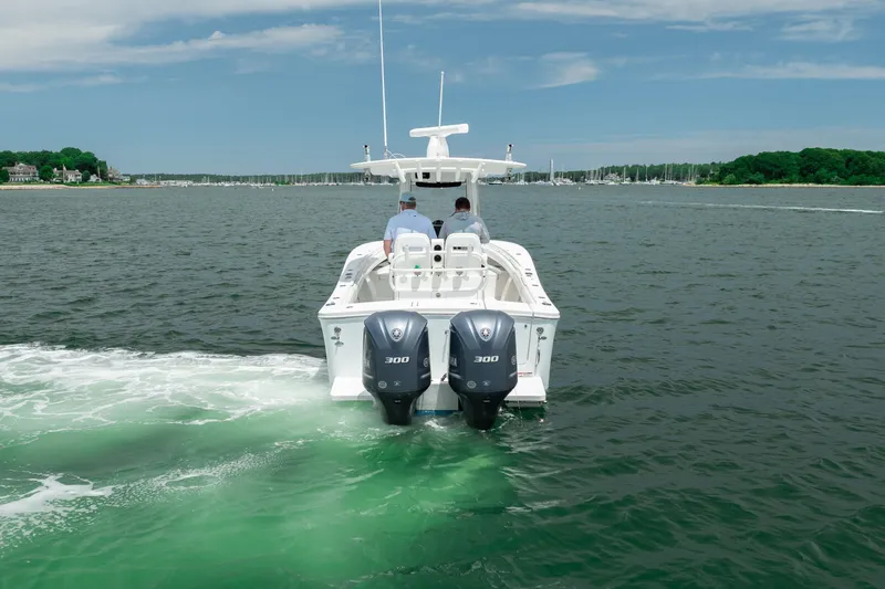 Slide: The Image of 2021 Regulator 28 Forward Seating boat cruising on a scenic lake with twin engines. - 5
