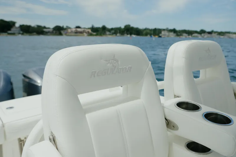 Slide: The Image of 2021 Regulator 28 Forward Seating boat with white leather seats on a sunny day. - 17