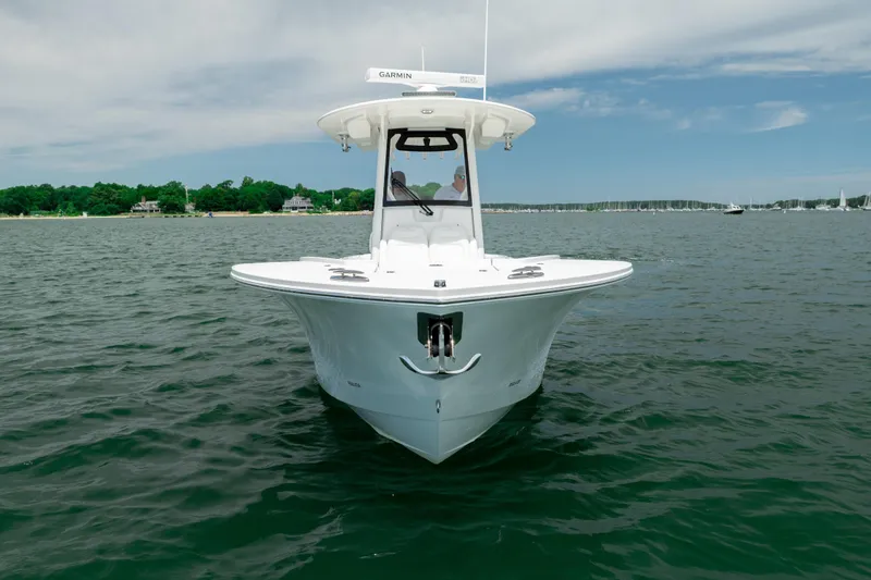 Slide: The Image of 2021 Regulator 28 Forward Seating boat on calm water, front view. - 2