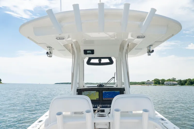 Slide: The Image of 2021 Regulator 28 Forward Seating boat helm with dual displays on calm water. - 19