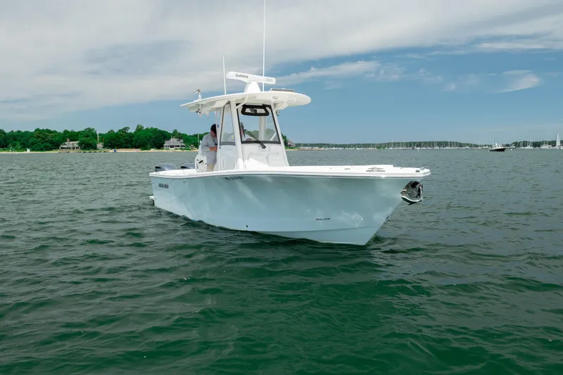 Slide: The Image of 2021 Regulator 28 Forward Seating boat on calm water under a clear sky. - 6