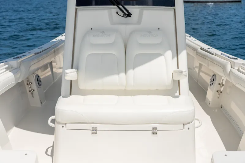 Slide: The Image of 2021 Regulator 28 Forward Seating boat with white cushioned seats on open water. - 13