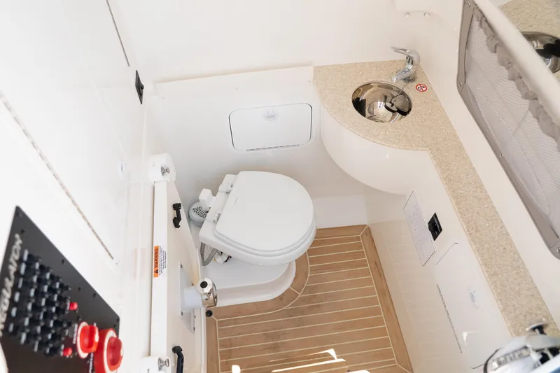 Slide: The Image of 2021 Regulator 28 Forward Seating boat bathroom with toilet and sink. - 21