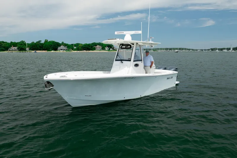 Slide: The Image of 2021 Regulator 28 Forward Seating boat on calm water, featuring sleek design and modern amenities. - 3