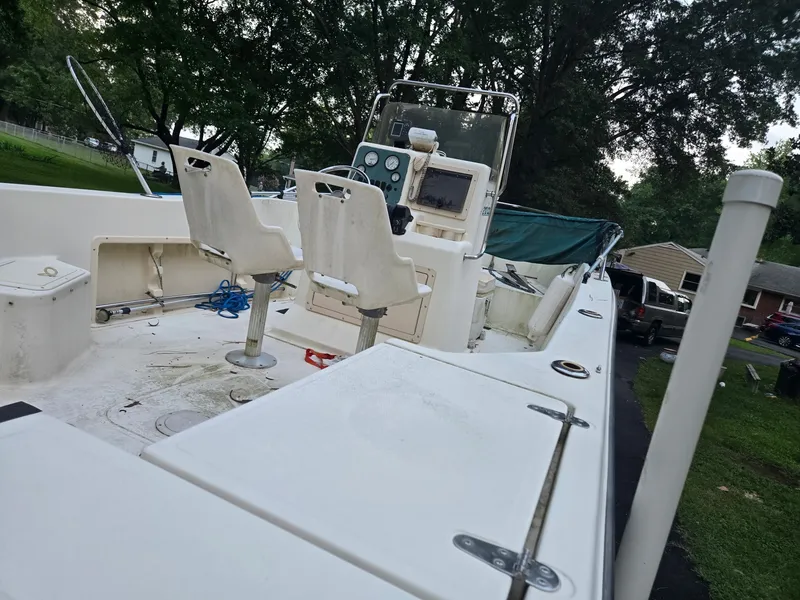 Slide: The Image of A 1999 Sea Pro 210 Center Console boat with two seats and helm, surrounded by trees. - 4