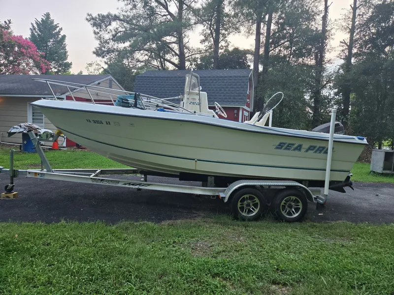 The Image of A 1999 Sea Pro 210 Center Console boat on a trailer in a yard. - 0